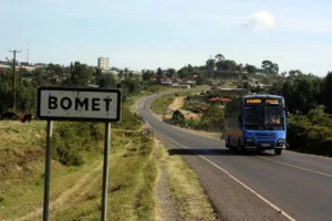Bomet County road sign with a blue bus approaching a rural town, symbolizing smart healthcare expansion in Kenya